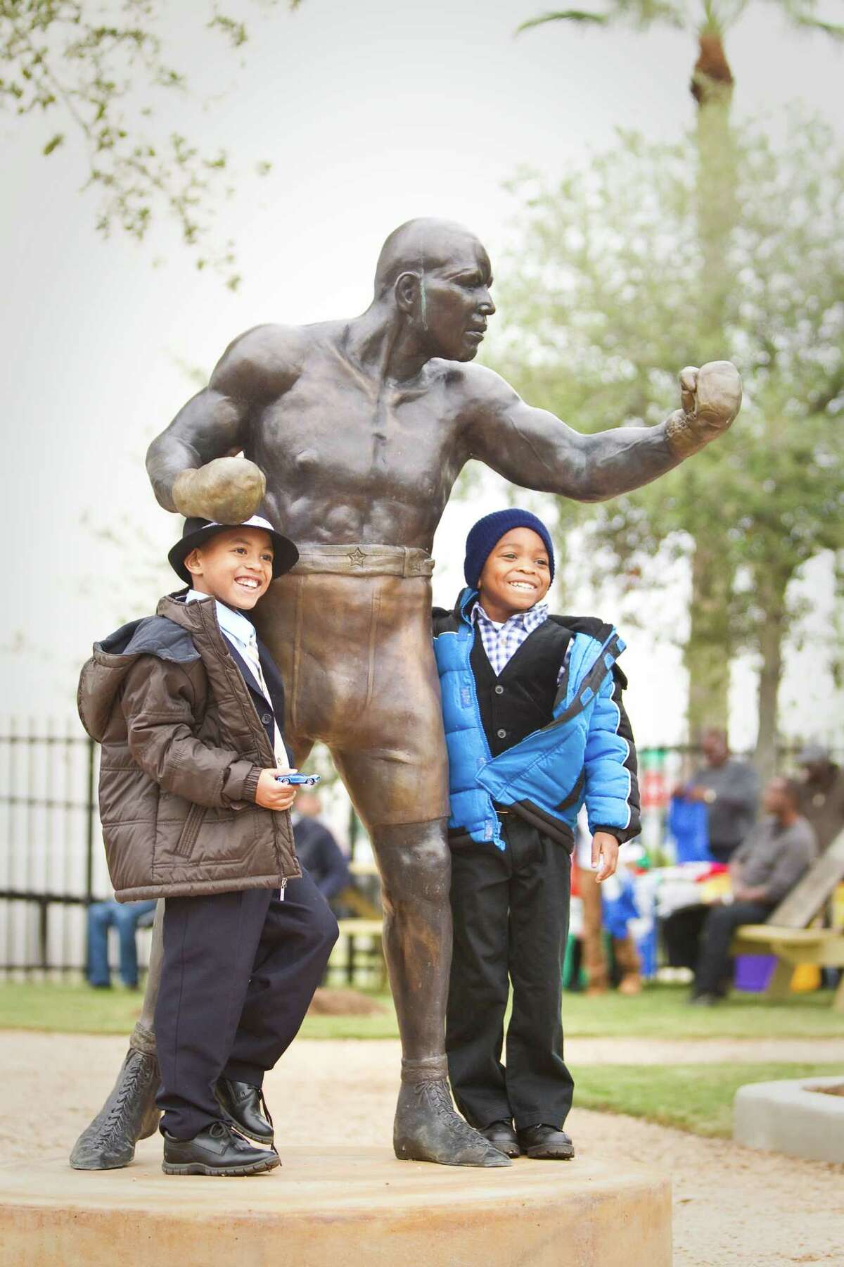 Jedadiah Baker, of Austin, left, and his cousin Daniel Speights, of Missouri City, poses for a picture with a new statue of Jack Johnson after a dedication ceremony for Jack Johnson Park at the Old Central High School, Tuesday, in Galveston. Johnson was the first African American heavyweight champion.