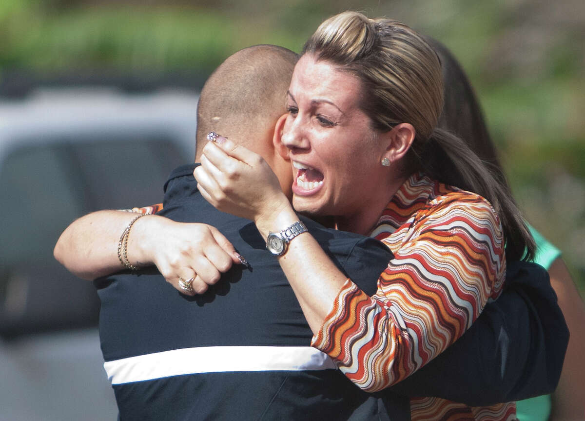 Laurel Sagastegui, right, hugs a man at a scene after her boyfriend was fatally shot and another wounded Wednesday, Nov. 14, 2012, in Channelview.