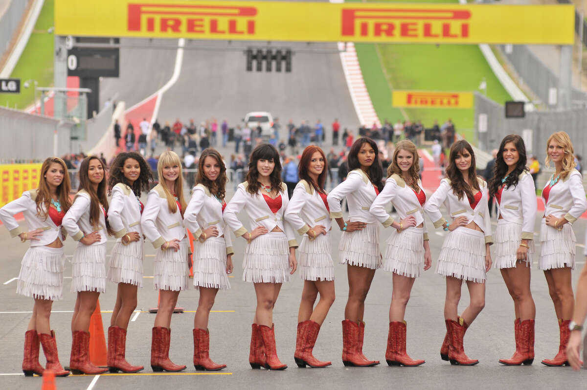 Formula 1 Grid Girls dressed in a Texas motif pose for pictures along the main straight of the Circuit of the America's Thursday morning near Austin.