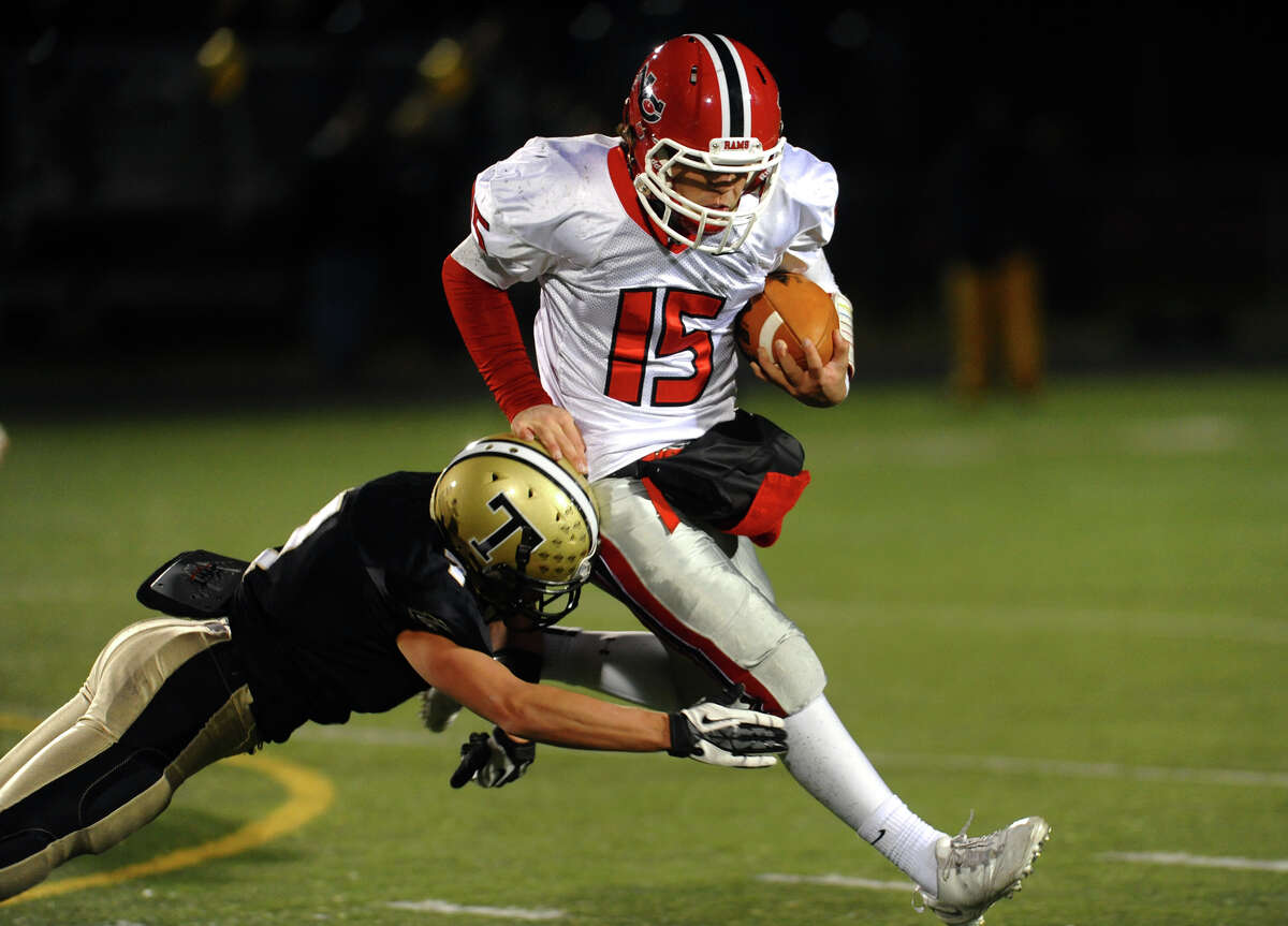 New Canaan QB Nick Cascione tries to avoid a tackle by Trumbull's #7 Thomas Hayduk, during boys football action in Trumbull, Conn. on Friday November 16, 2012.