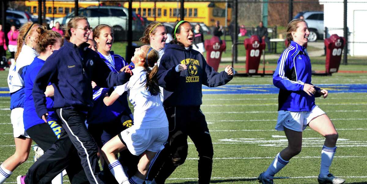 Newtown High School girls soccer celebrates beating New Milford in the Class LL state semifinals at Waterbury Saturday, Nov. 17, 2012.