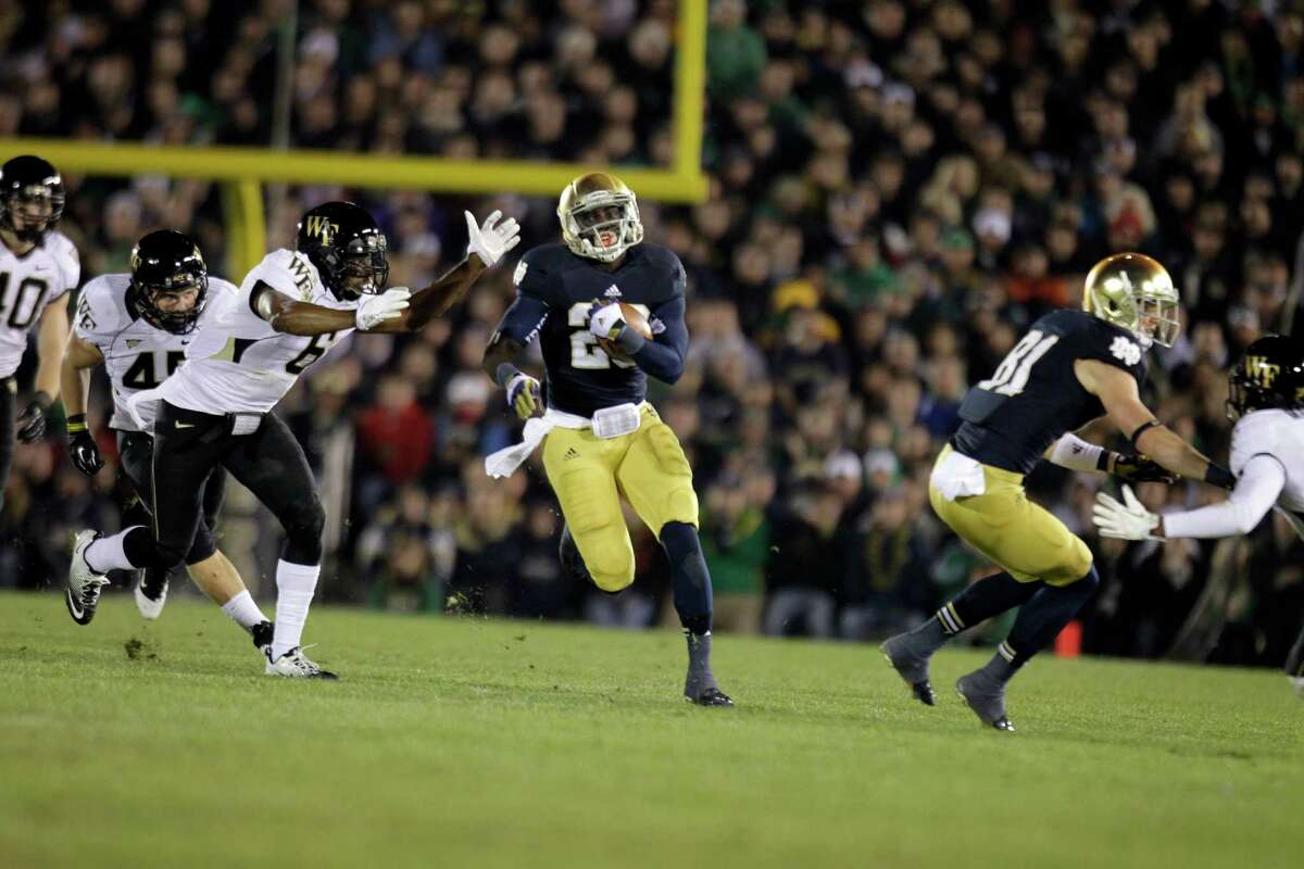 Notre Dame running back Cierre Wood (20) cuts around Wake Forest defenders as he picks up 42 yards during the second half of an NCAA college football game in South Bend, Ind., Saturday, Nov. 17, 2012. Notre Dame defeated Wake Forest 38-0. (AP Photo/Michael Conroy)