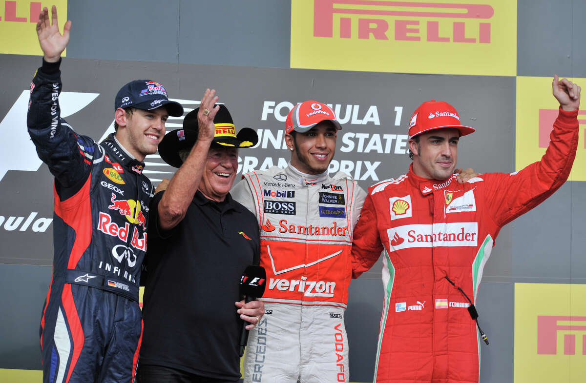 Lewis Hamilton (2nd from right) celebrates winning the US Grand Prix with 2nd place finisher Sebastian Vettel (left) racing legend Mario Andretti (2nd from left) and 3rd place finisher Fernando Alonso (right)after the race Sunday.