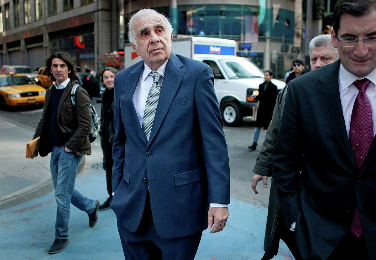 Carl Icahn, billionaire investor and chairman of Icahn Enterprises Holdings LP, center, walks outside of the Nasdaq MarketSite with Robert Greifeld, chief executive officer and president of Nasdaq OMX Group Inc., in New York, U.S., on Tuesday, March 27, 2012. Icahn announced his intention last month to offer $30 a share and give CVR Energy Inc. holders a right to as much as an additional $7 a share, a proposal that values the company at at least $2.6 billion, according to Bloomberg calculations. Photographer: Scott Eells/Bloomberg *** Local Caption *** Carl Icahn; Robert Greifeld