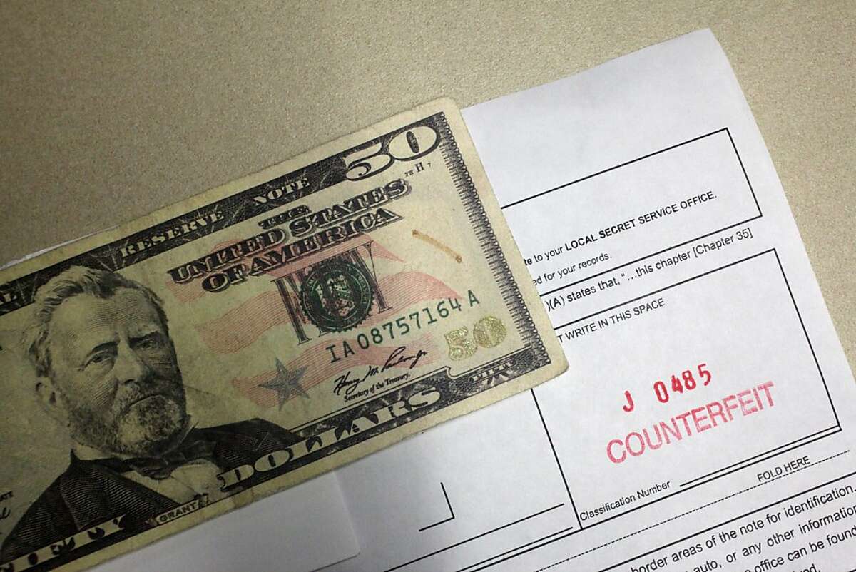 A counterfeit $50 bill is attached to a Counterfeit Note Report at the United States Secret Service San Francisco Field Office on Thursday, November 15, 2012 in San Francisco, Calif.
