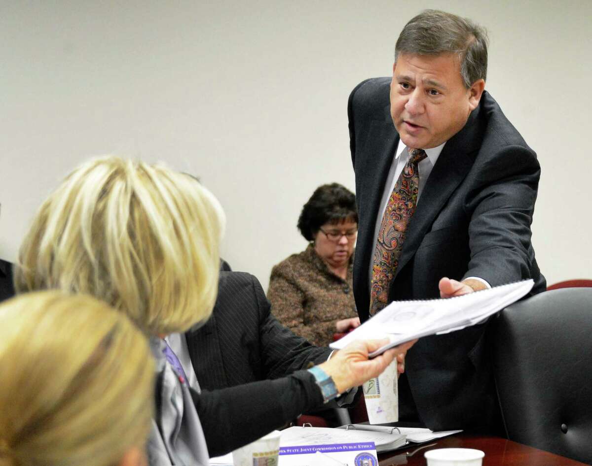 Ethics compliance consultant David Grandeau hands a complaint against state Comptroller Tom DiNapoli to NY State's ethics commission chair Janet DiFiore during the commission's Tuesday meeting in Albany Nov. 20, 2012. (John Carl D'Annibale / Times Union)