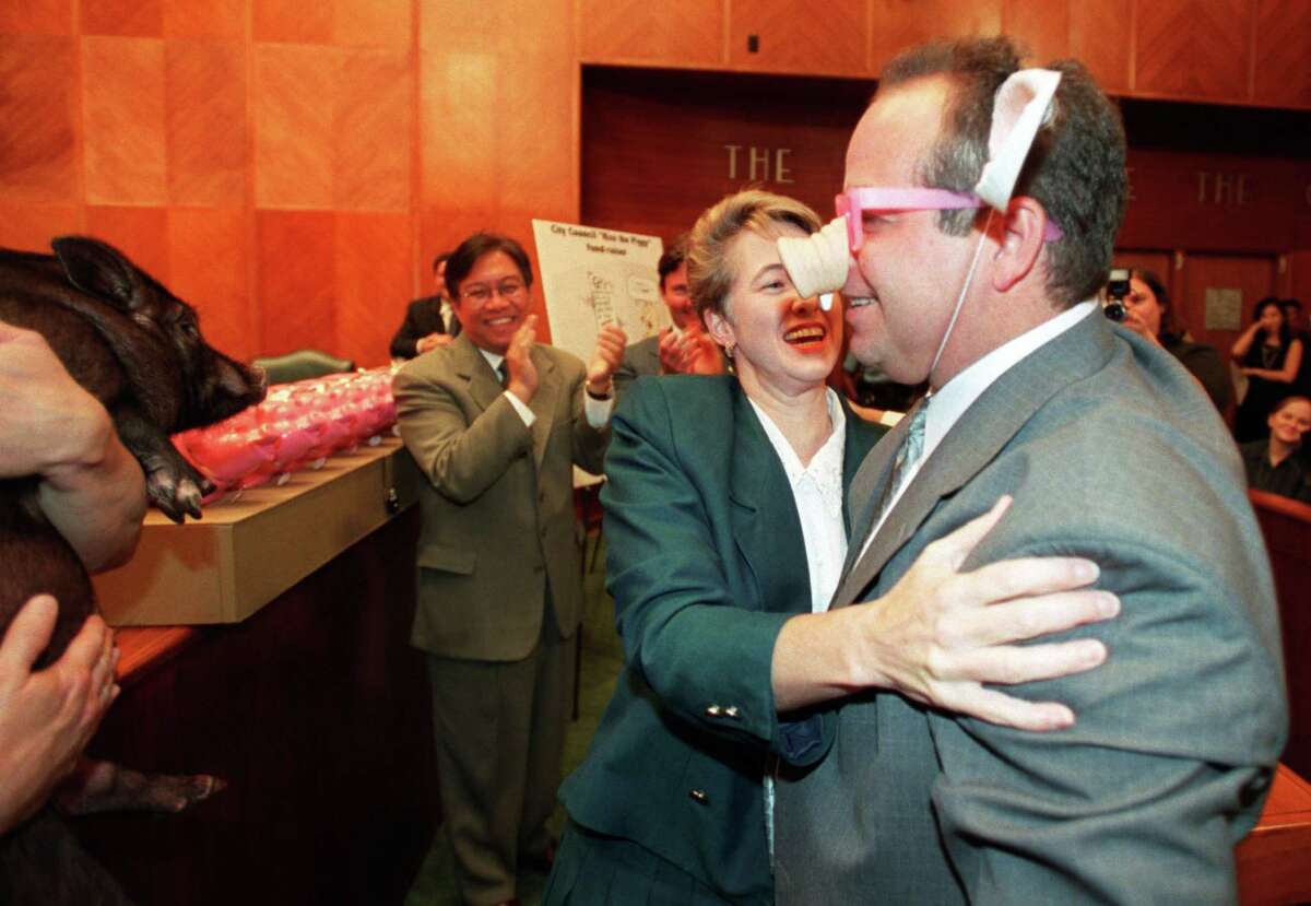 CONTACT FILED: HOUSTON, TEXAS-CITY COUNCIL 9/17/02--Houston City Council member Annise Parker prepares to embrace Wayne Dolcefino during Tuesday's council session. Parker was representing City Council in the "Kiss a Pig" fund-raising campaign. Dolcefino, wearing a pig nose and ears costume, was substituting for "Wilbur" held by City of Houston employee, Roger Smith (left). (on the staff of the Houston's Public Information Officer Cindy Sax). HOUCHRON CAPTION (09/18/2002): Councilwoman Annise Parker chose to kiss KTRK-TV Channel 13 reporter Wayne Dolcefino rather than Wilbur the pot-bellied pig Tuesday as part of the "Kiss a Pig" charity fund-raiser. The council member with the lowest contributions, Shelley Sekula-Gibbs, was supposed to have puckered up to the pig but was a late arrival to the ceremony. City Council raised more than $16,000, which will benefit hundreds of local charities.