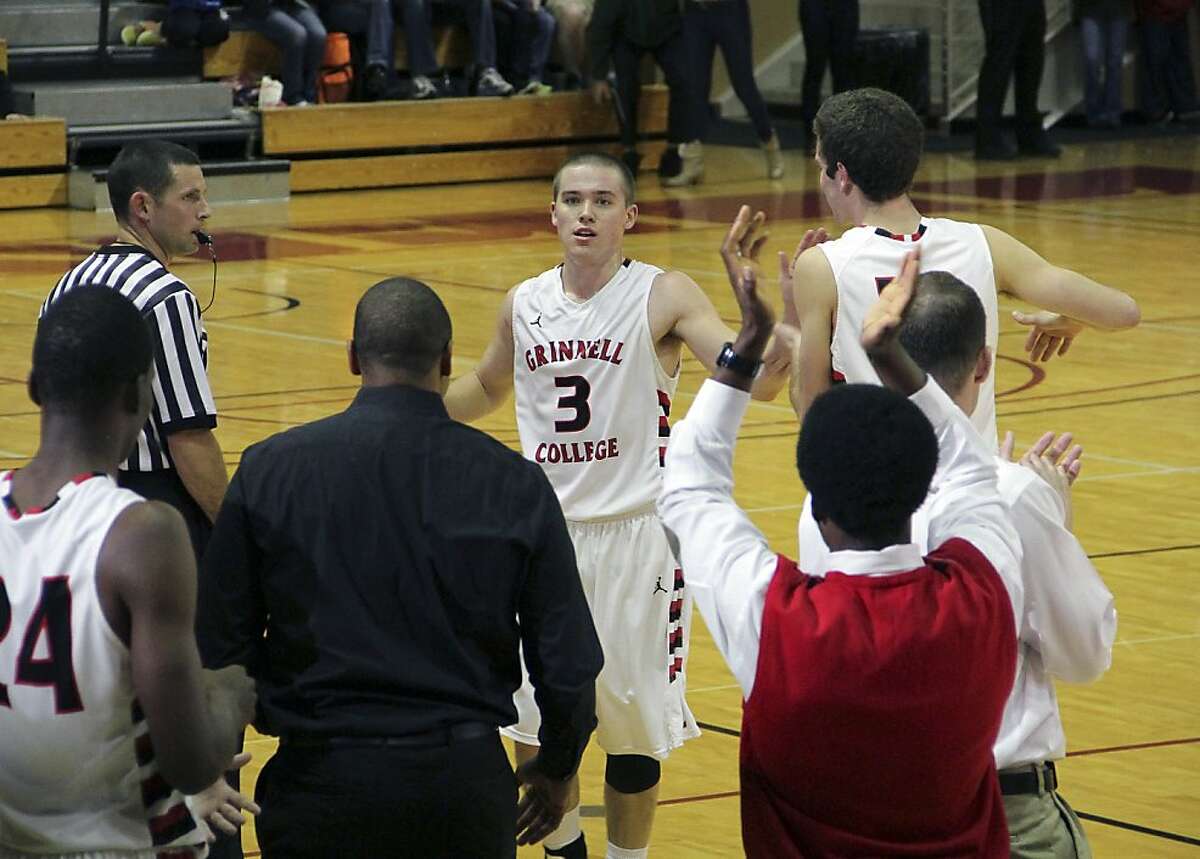 In this photo taken, Tuesday, Nov. 20, 2012, and provided by Grinnell College, Grinnell's Jack Taylor (3) is congratulated by teammates after an NCAA college basketball game against Faith Baptist Bible in Grinnell, Iowa. Taylor shattered the NCAA scoring record with 138 points, hoisting a mind-boggling 108 attempts _ or one shot every 20 seconds _ in eclipsing the previous record by 25 points. (AP Photo/Grinnell College, Cory Hall)