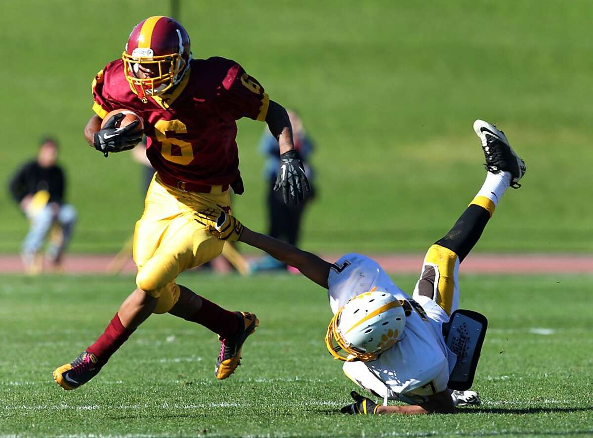 Lincoln's Demetrius Williams escapes a Bears tackler at Kezar Stadium The Lincoln Mustangs played the Mission Bears in the annual AAA/SF Section Varsity Football "Turkey Day" championship game in San Francisco Thursday Nov. 22, 2012.Lincoln won 22-21