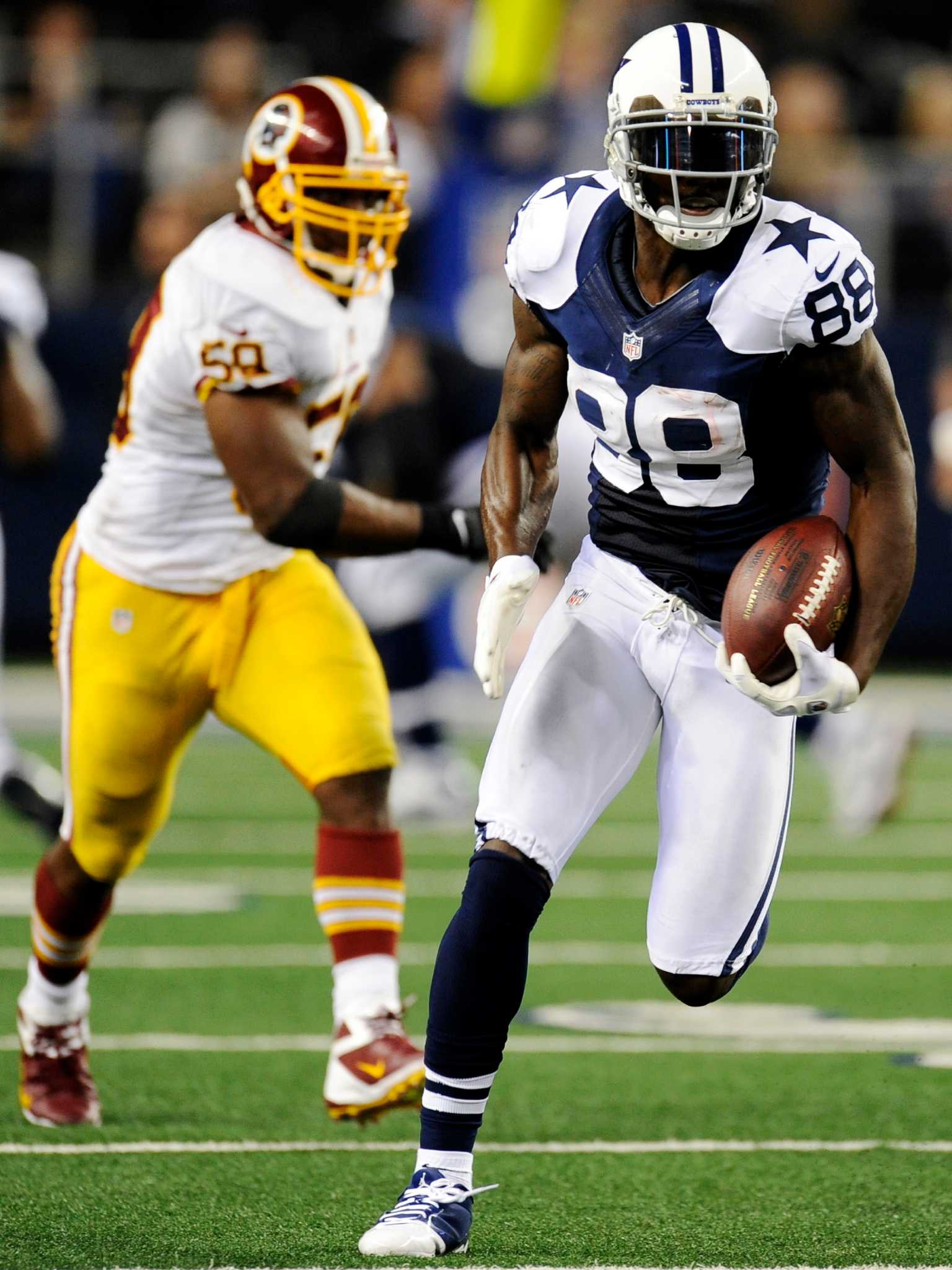 Dallas Cowboys wide receiver Dez Bryant (88) eludes Washington Redskins  defenders to take a Tony Romo pass for 85 yards and a touchdown in the  third quarter at Cowboys Stadium in Arlington