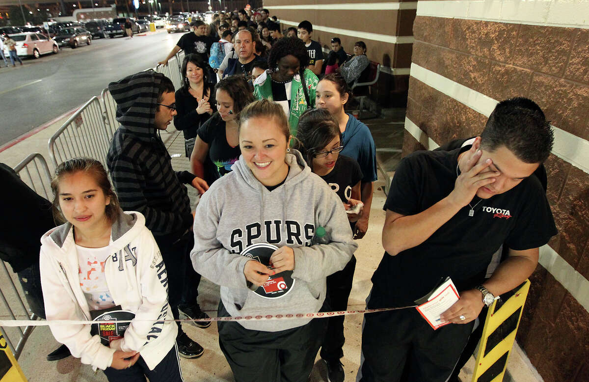 Cousins Ashley Martinez (from left), Crystal Lozano and Zac Leard wait out the last remaining moments after being in line since 8 a.m. to be the first shoppers at Super Target at Wonderland of the Americas. Target opened at 9 p.m. on Thanksgiving Day.