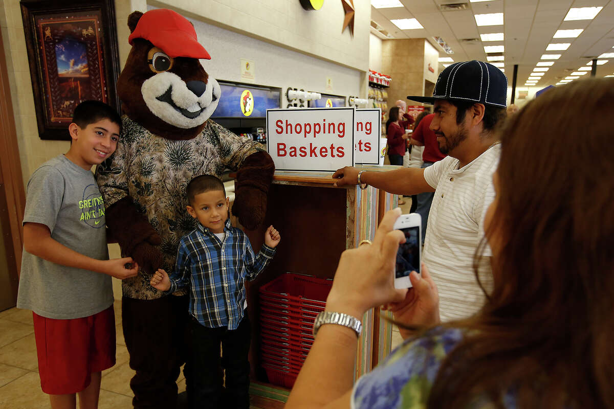 Jason Torres, left, and Angel Monroy strike a pose with the Buc-ee's Beaver mascot in Luling on Friday.