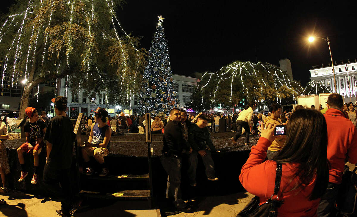 Families gather for photos at Alamo Plaza after the 28th Annual H-E-B Tree Lighting Ceremony on Friday, Nov. 23, 2012. The 55-foot tall fir tree was lit with 10,000 LED lights and with 450 ornaments. The event kicked off the holiday season followed by the 30th Annual Ford Holiday River Parade & Lighting Ceremony along the San Antonio River.