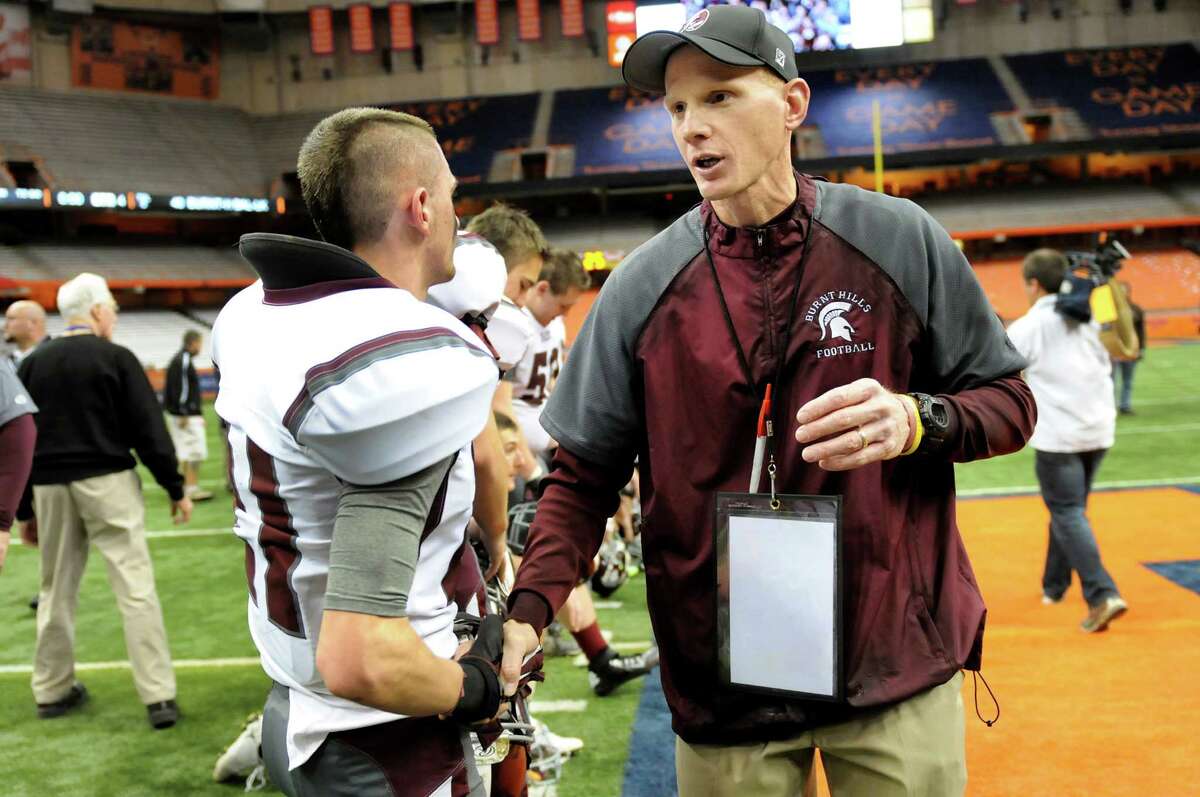 Burnt Hills coach Matt Shell, center, congratulates each player after they won 40-14 over Sweet Home in their Class A football state final on Friday, Nov. 23, 2012, at the Carrier Dome in Syracuse.