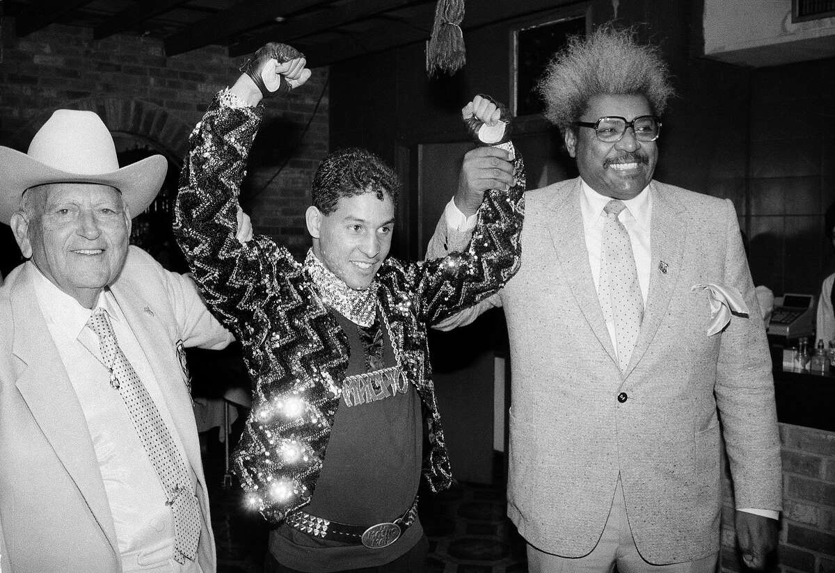 In this Dec. 9, 1986 file photo, Hector "Macho" Camacho WBC lightweight boxing champion, is escorted by Marty Cohen, left, and boxing promoter Don King, right, during a news conference in New York. Famed Puerto Rican boxer Camacho is clinically brain dead, doctors said Thursday, Nov. 22, 2012, though they said family members were disagreeing on whether to take him off life support. Dr. Ernesto Torres said doctors have finished performing all medical tests on Camacho, who was shot in the face Tuesday night. (AP Photo/David Bookstaver, File)