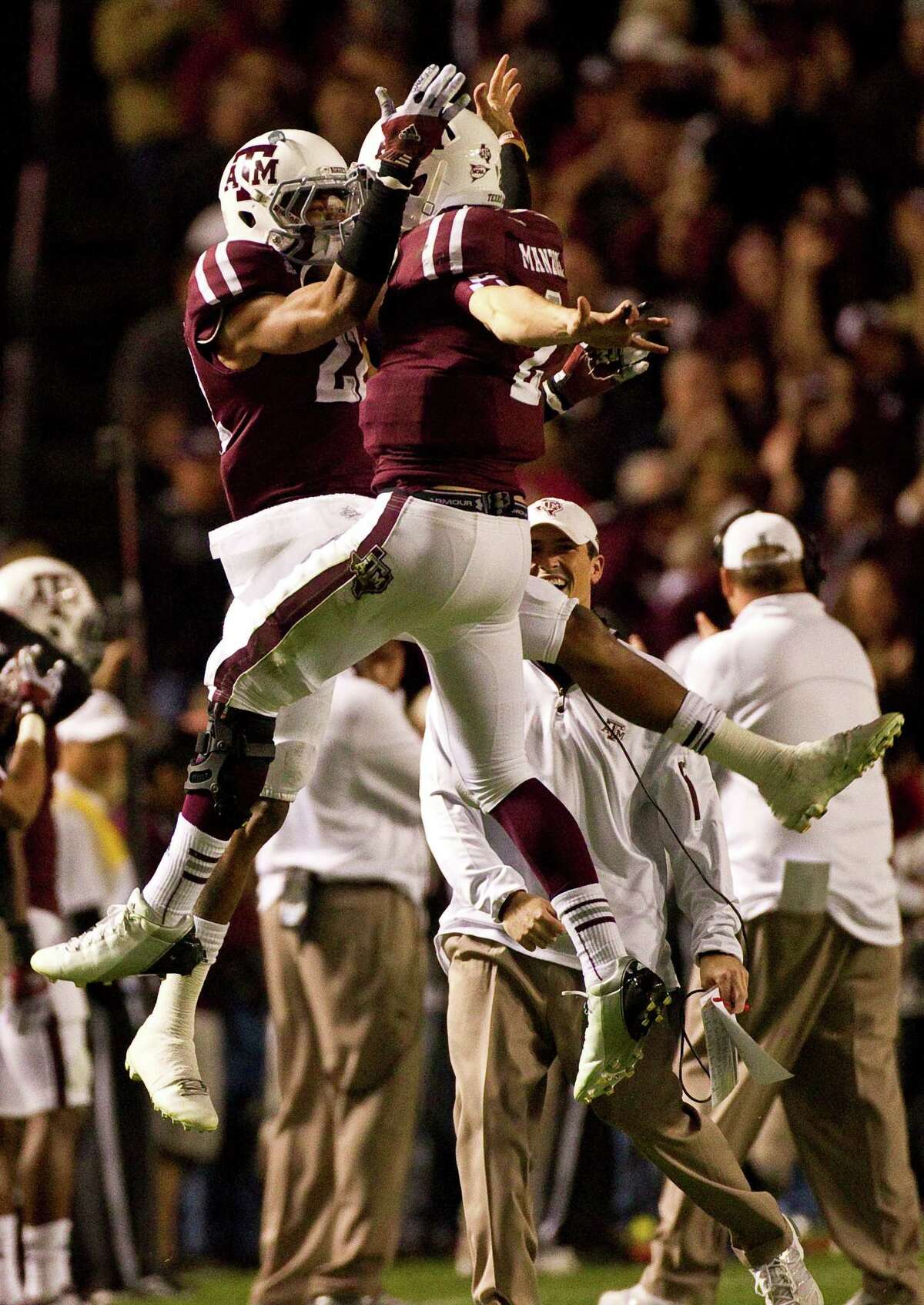 Texas A&M defensive back Dustin Harris (22) and Texas A&M quarterback Johnny Manziel (2) celebrate after Manziel threw a touchdown pass during the second quarter of a NCAA football game, Saturday, Nov. 24, 2012, in Kyle Field in College Station.