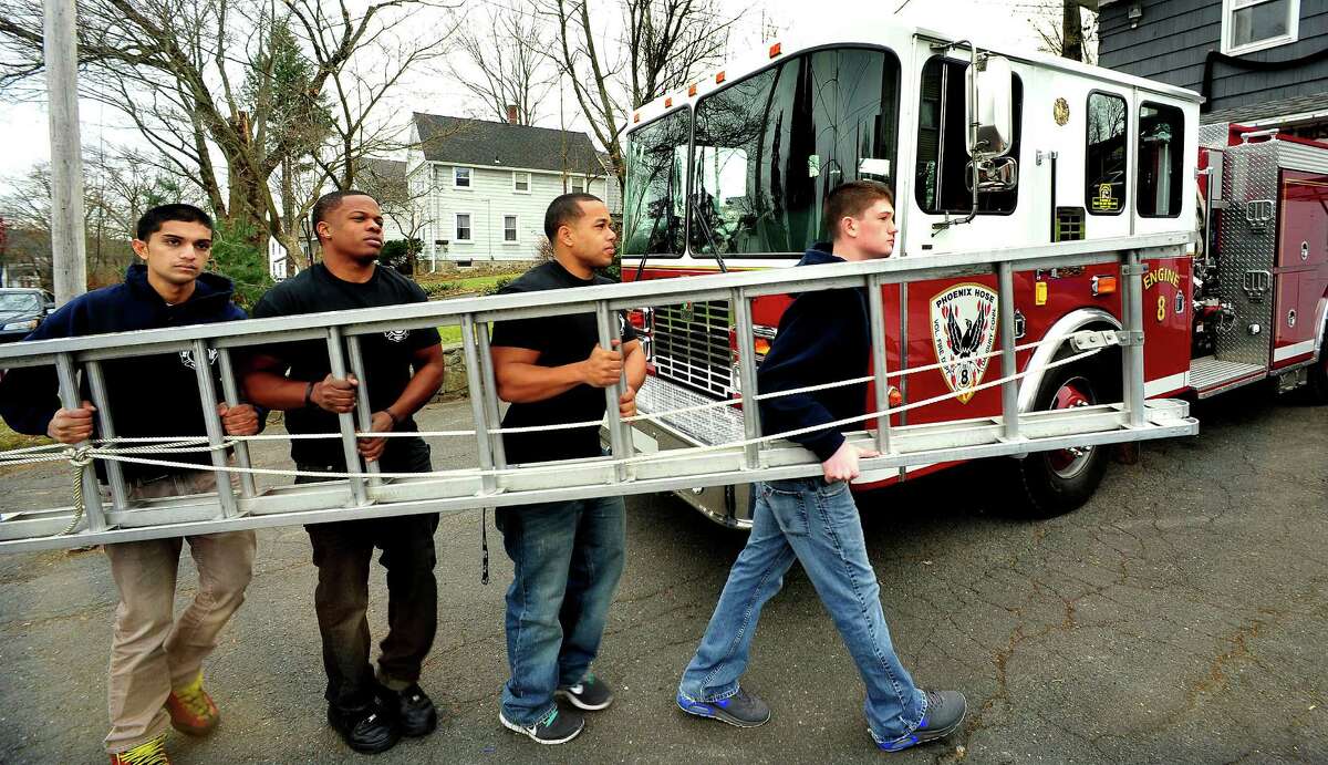 Volunteer firefighters move a ladder at Engine 8 Phoenix Hose Company in Danbury Sunday, Nov. 25, 2012. From left are Dev Patel, Vincent Mourning, Alan Nunez and Sean Stoeckle.