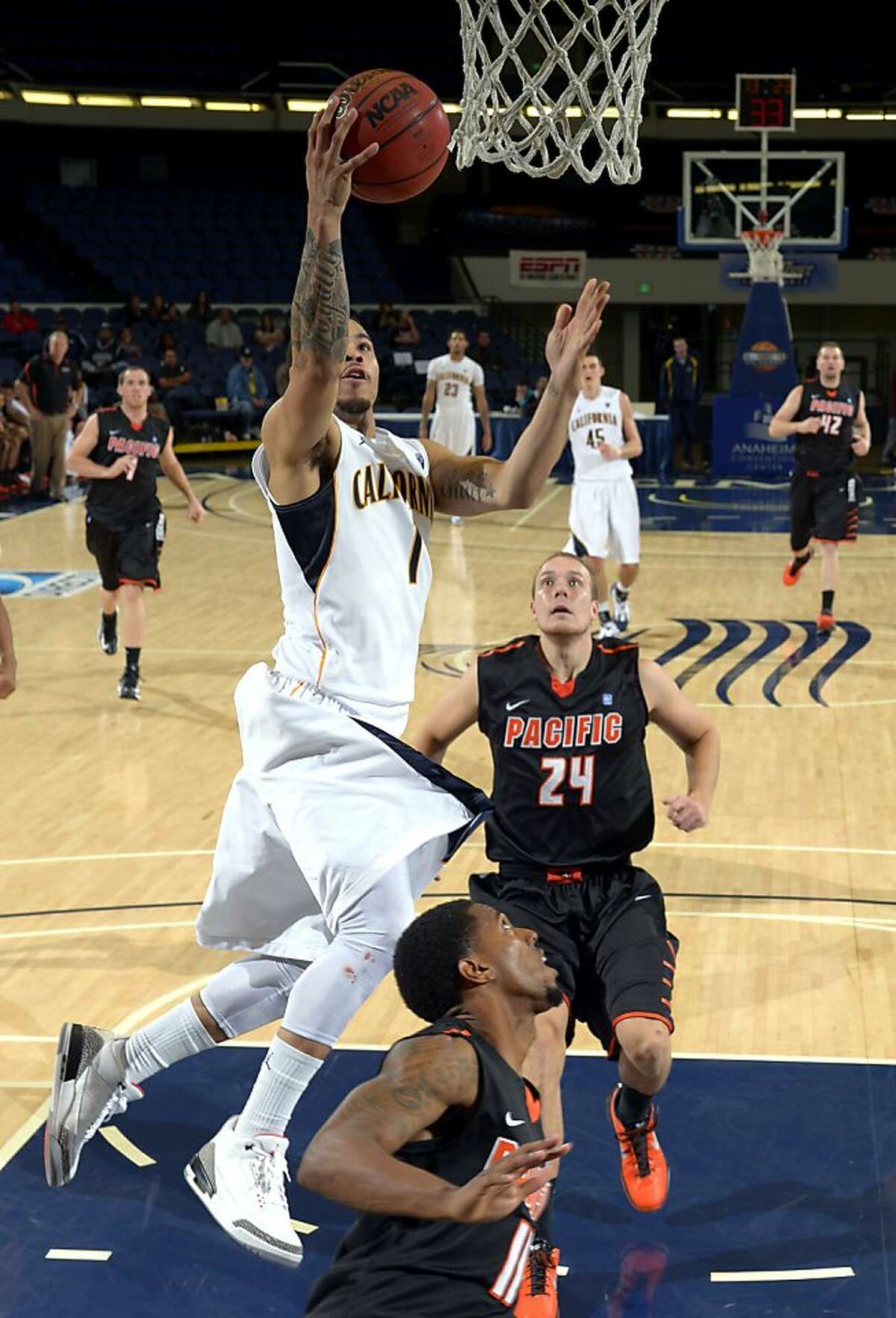 California's Justin Cobbs, left, puts up a shot as Pacific's Lorenzo McCloud, below, and Travis Fulton right look on during the second half of their NCAA college basketball game at the DirecTV Classic final, Sunday, Nov. 25, 2012, in Anaheim, Calif. California won 78-58. (AP Photo/Mark J. Terrill)