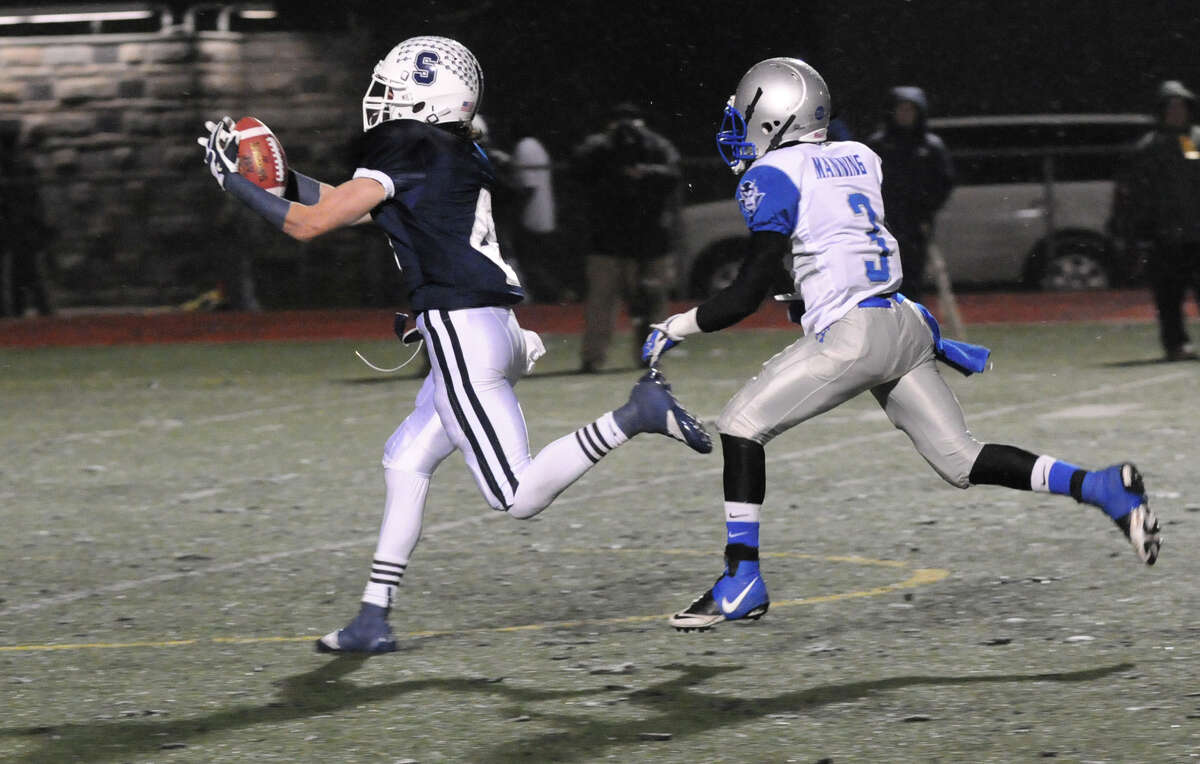 Staples' James Frusciante receives as West Haven's Jawaun Manning closes in as Staples High School hosts West Haven in a Class LL football quarterfinals game in Westport, Conn., Nov. 27, 1012.
