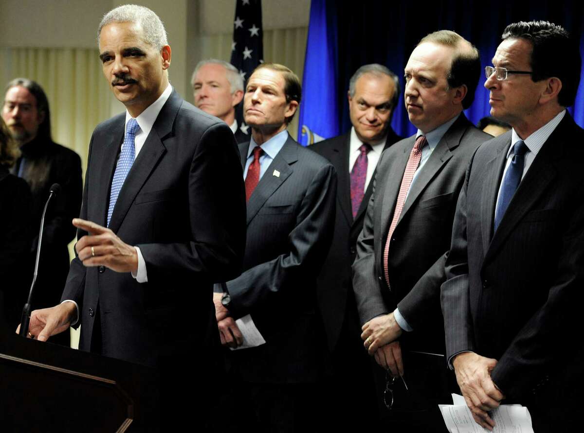 U.S. Attorney General Eric Holder, left, speaks at a news conference to announce a new effort to reduce gun violence in the state's major cities in New Haven, Conn., Tuesday, Nov. 27, 2012. The nation’s top prosecutor and other officials have announced a new effort to reduce gun violence in the Connecticut major cities by directly engaging violent groups.