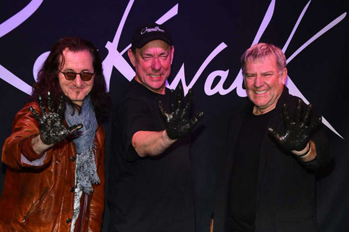 Rush members (from left) Geddy Lee, Neil Peart and Alex Lifeson were honored on Guitar Center's RockWalk this month in Hollywood. Getty Images