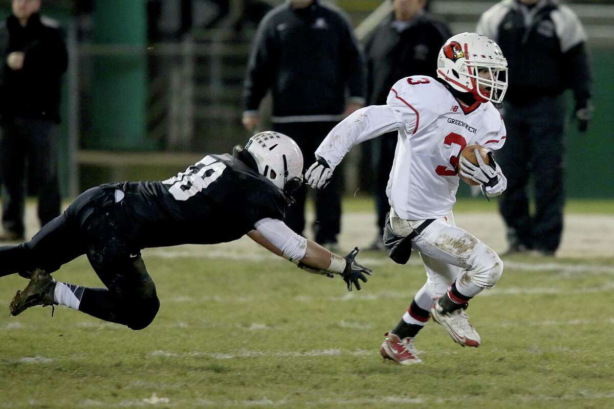 Mike Ross Connecticut Post freelance -Greenwich High School's # 3 Austin Longi escapes a tackle and makes a 67 yard touchdown run during Wednesday evening Class LL football quarterfinals against Xavier.