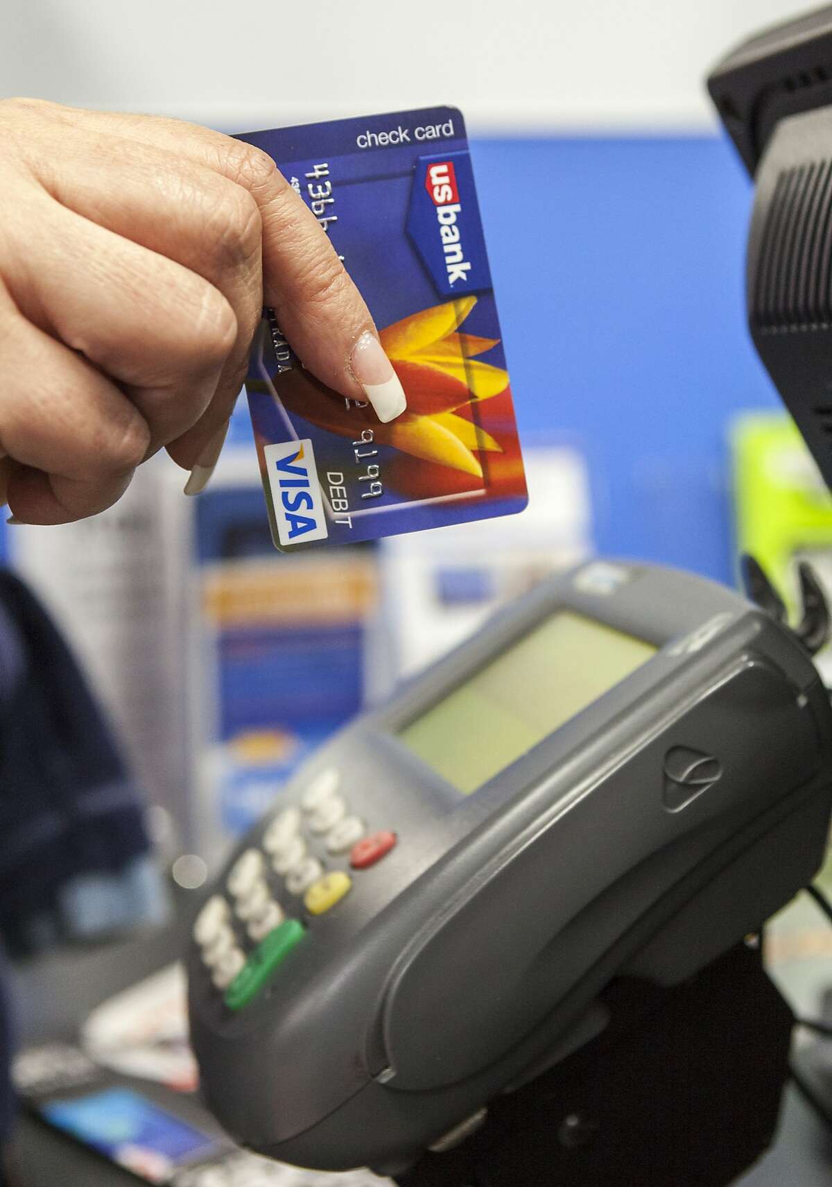 A consumer pays with a US Bank VISA debit card, as she shops for Thanksgiving celebrations at the Pre-Black Friday event at the Walmart Supercenter store in Rosemead, Calif., Wednesday, Nov. 21, 2012. (AP Photo/Damian Dovarganes)