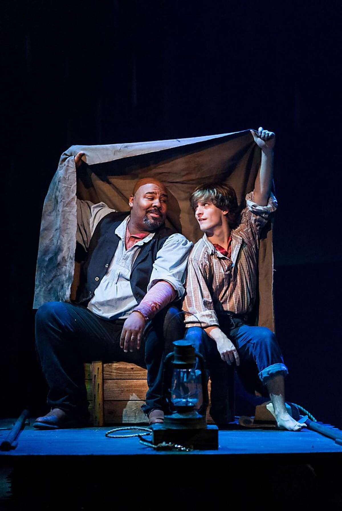 Huck (Alex Goley, right) and Jim (James Monroe Iglehart) shelter from the rain in the musical "Big River" at TheatreWorks