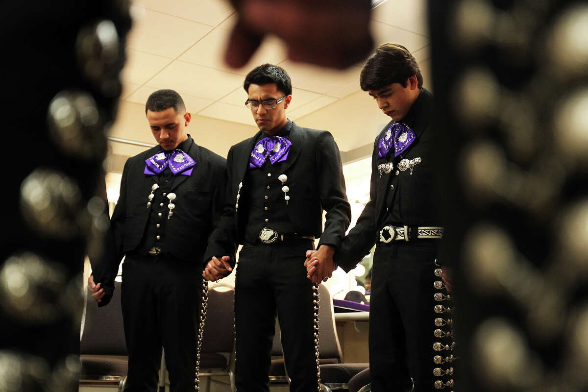 Mariachi Pantera from Jefferson Davis High School in Houston says a prayer led by Carlos Torres, center (holding hands with Edgar Menendez, left, and Oscar Montes, right) as they prepare for their performance in the Group Competition during the 18th annual Mariachi Vargas Extravaganza at Lila Cockrell Theatre, Friday, November 30, 2012.