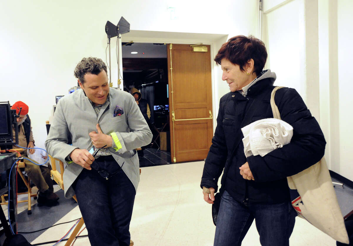 Fashion designer Isaac Mizrahi, left, gives a bit of fashion mentoring to Greenwich resident, Lynne Jassem, on the set of the Showtime television series "The Big C," that was videotaping at the YMCA of Greenwich, Tuesday afternoon, Nov. 27, 2012. Jassem, a member of the Greenwich YMCA, was passing through the set when she noticed Mizrahi and went over to speak to him. "Hhe's my favorite designer," she said. Mizrahi is guest-starring on the show as himself, playing the role of a fashion mentor.