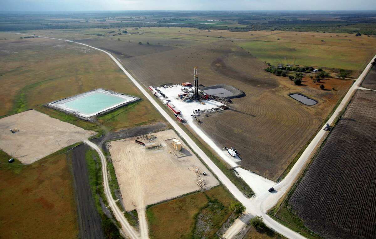 A cluster of well pad sites, including one with an active drilling rig, in the Eagle Ford shale oil play near Kenedy are seen in this Friday Nov. 23, 2012 aerial photo.