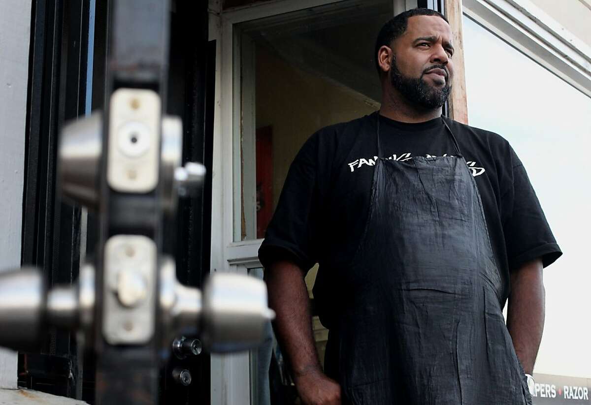 Robeson Perry, owner of Famous One's Barber Shop stands outside his shop on International Boulevard, Friday November 30, 2012, in Oakland, Calif.