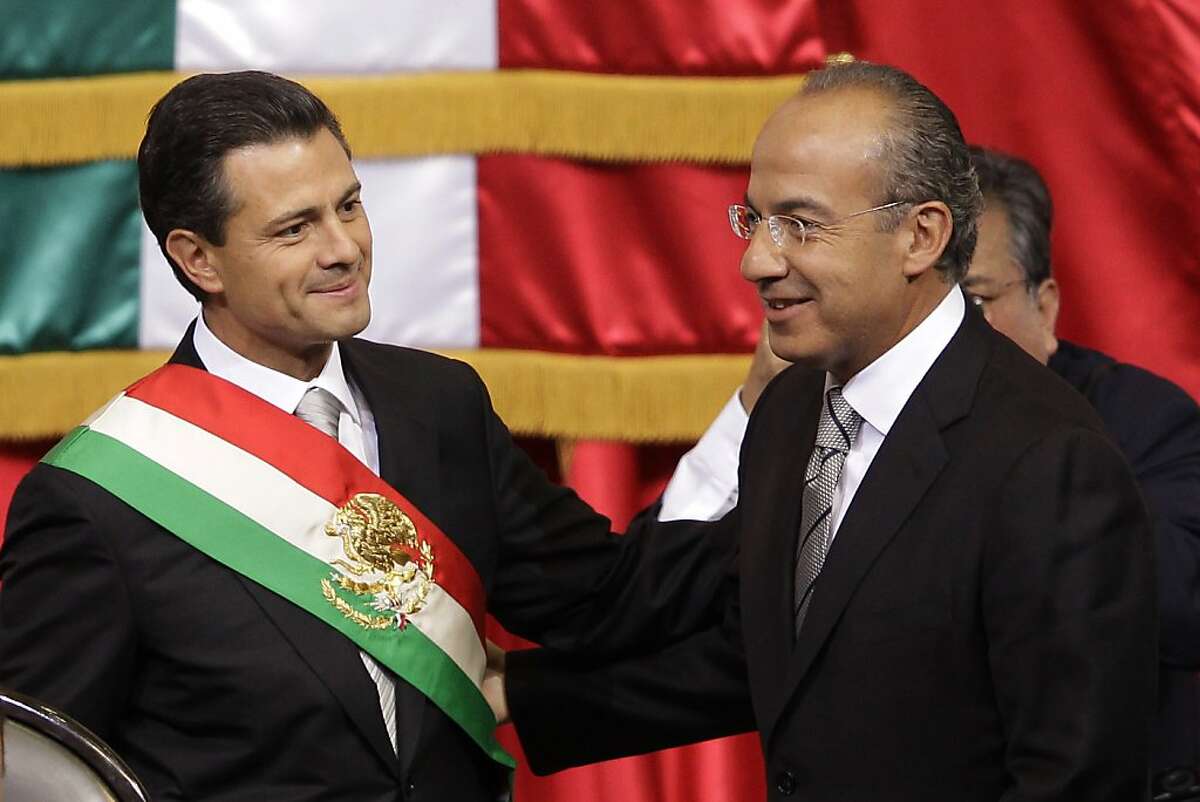 Mexico's incoming President, Enrique Pena Nieto, left, smiles as he stands with outgoing President Felipe Calderon during the inauguration ceremony at the National Congress in Mexico City, Saturday, Dec. 1, 2012. Pena Nieto took the oath of office as Mexico's new president on Saturday, bringing the old ruling party back to power after a 12-year hiatus amid protests inside and outside the congressional chamber where he swore to protect the constitution and laws of the land. (AP Photo/Alexandre Meneghini)