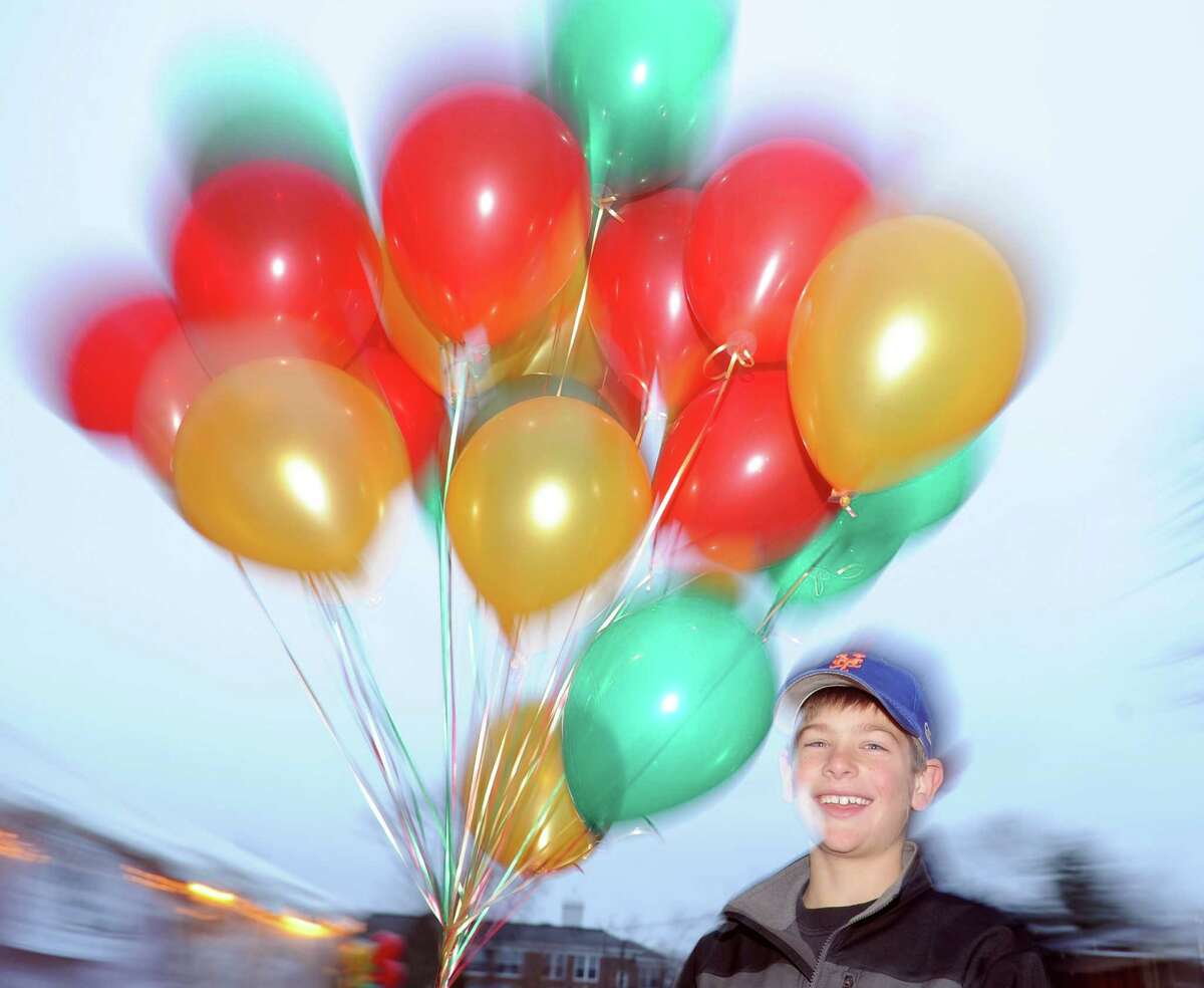 Andrew Scarlata, 10, of Cos Cob, holds a bunch of holiday balloons during the first Winter's Eve Festival behind the Cos Cob Firehouse, Saturday, Dec. 1, 2012.
