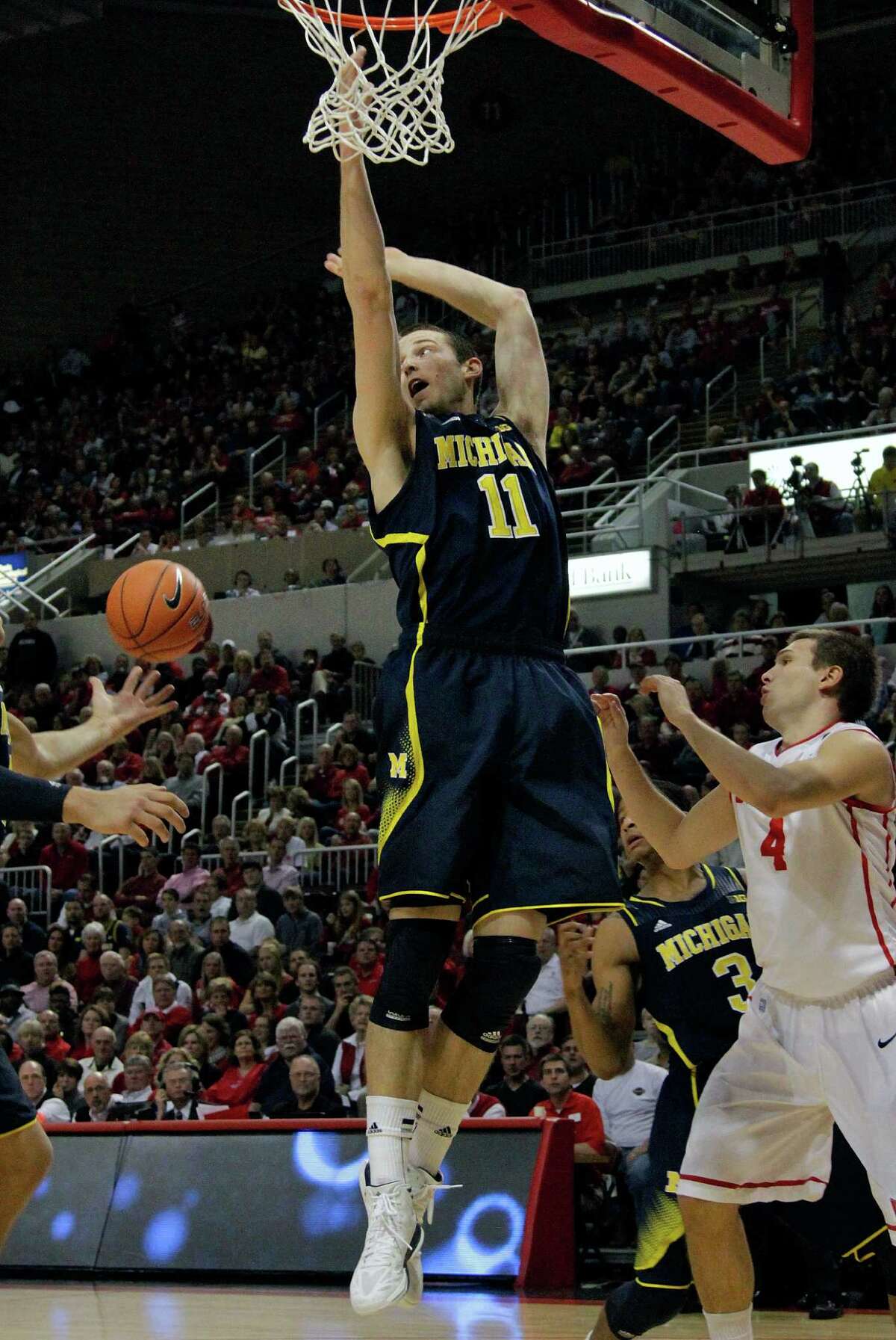 Michigan guard Nik Stauskas (11) fights for a rebound against Bradley's Jake Eastman (4) during the first half of an NCAA college basketball game on Saturday, Dec. 1, 2012, in Peoria Ill. (AP Photo/Seth Perlman)