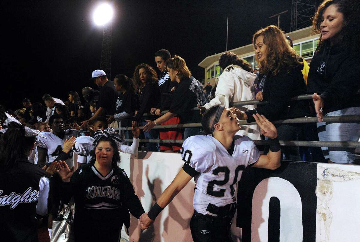 Steele receiver Matthew Mayle (20) holds the hand of his sister, cheerleader Lindsay Mayle, as they greet fans and family after Steele defeated Edinburg North in Class 5A Division II football playoffs action in Kingsville on Saturday, Dec. 1, 2012.