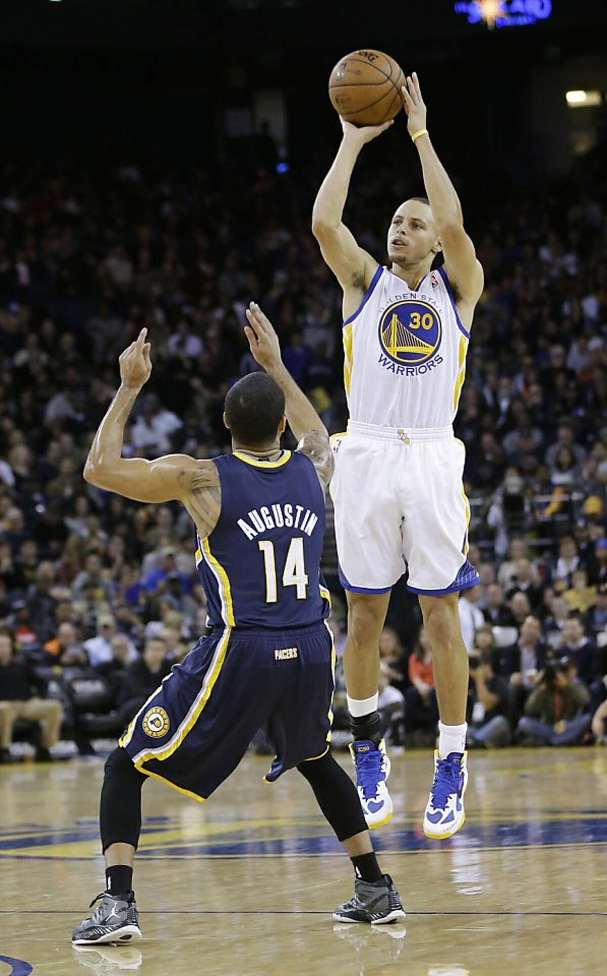 Golden State Warriors' Stephen Curry (30) shoots over Indiana Pacers' D.J. Augustin (14) during the first half of an NBA basketball game in Oakland, Calif., Saturday, Dec. 1, 2012. (AP Photo/Marcio Jose Sanchez)