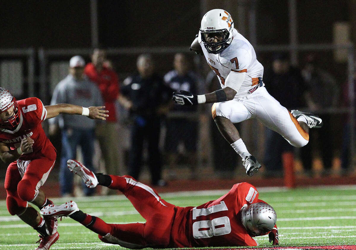 Madison's Marquis Warford (07) leaps over Mission Sharyland's Jon Barraza (18) in the second half in the Class 5A Div. I playoff game in Corpus Christi on Friday, Nov. 30, 2012.