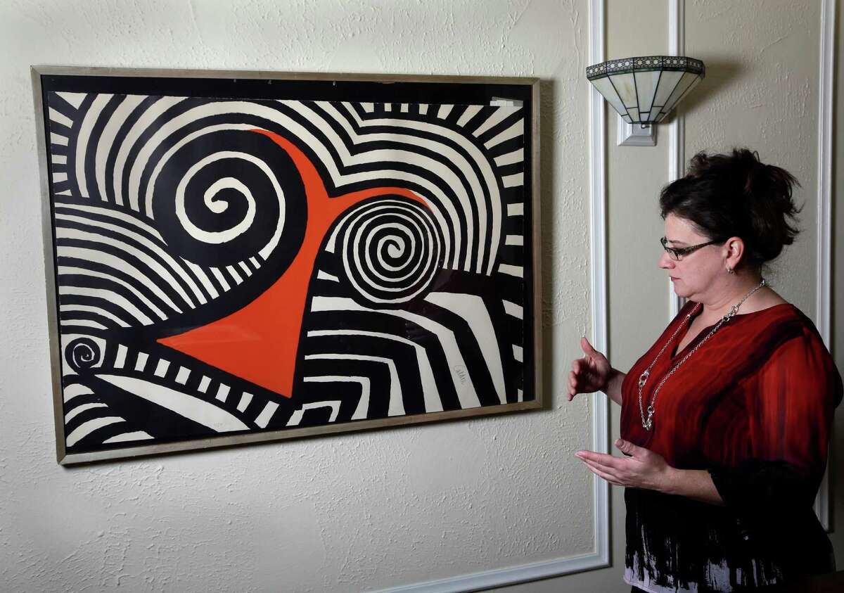 In this Wednesday, Nov. 28, 2012 photo, Karen Mallet stands by her Alexander Calder print in her Shorewood, Wis., home. Mallet bought the print for $12.34 at a Goodwill thrift store in Milwaukee. It turned out to be a lithograph by the American artist Alexander Calder worth $9,000. (AP Photo/Morry Gash)
