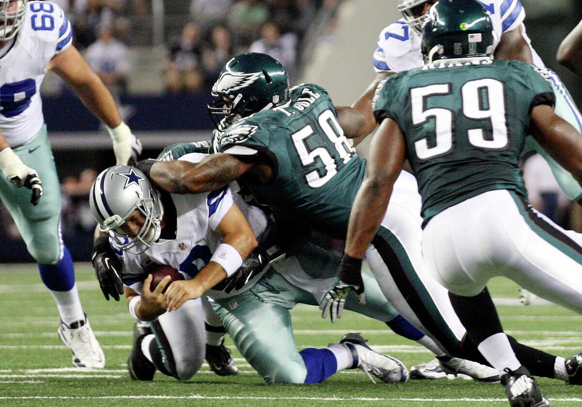 Dallas Cowboys' quarterback Tony Romo is sacked by Philadelphia Eagles' defensive ends Brandon Graham, (54), and Trent Cole, (58), during the first half at Cowboys Stadium in Arlington, Texas, Sunday, Dec. 2, 2012.