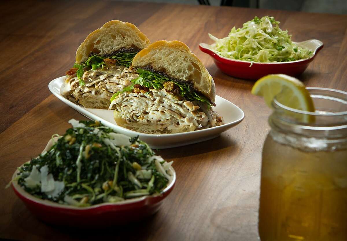 The Rotisserie Porchetta with sides of Cole Slaw, rear, and Kale Salad at Split Bread in San Francisco, Calif., are seen on Friday, November 30th, 2012.