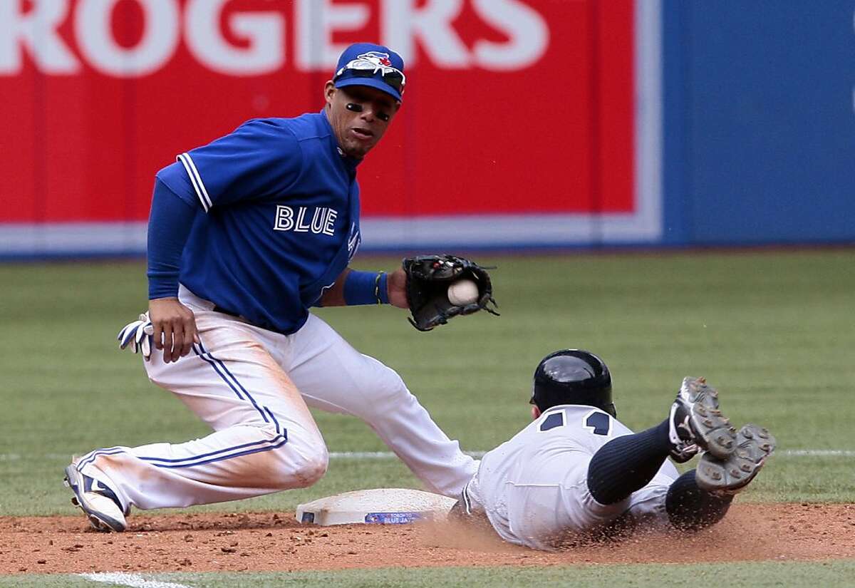 FILE - NOVEMBER 13: According to reports, the Miami Marlins will trade Jose Reyes, Josh Johnson, Mark Buehrle, John Buck and Emilio Bonifacio to the Toronto Blue Jays for Yunel Escobar, and prospects Jake Marisnick and Adeiny Hechevarria. TORONTO, CANADA - SEPTEMBER 29: Yunel Escobar #5 of the Toronto Blue Jays makes the play to catch Brett Gardner #11 of the New York Yankees stealing at second during MLB action at the Rogers Centre September 29, 2012 in Toronto, Ontario, Canada. (Photo by Abelimages/Getty Images)