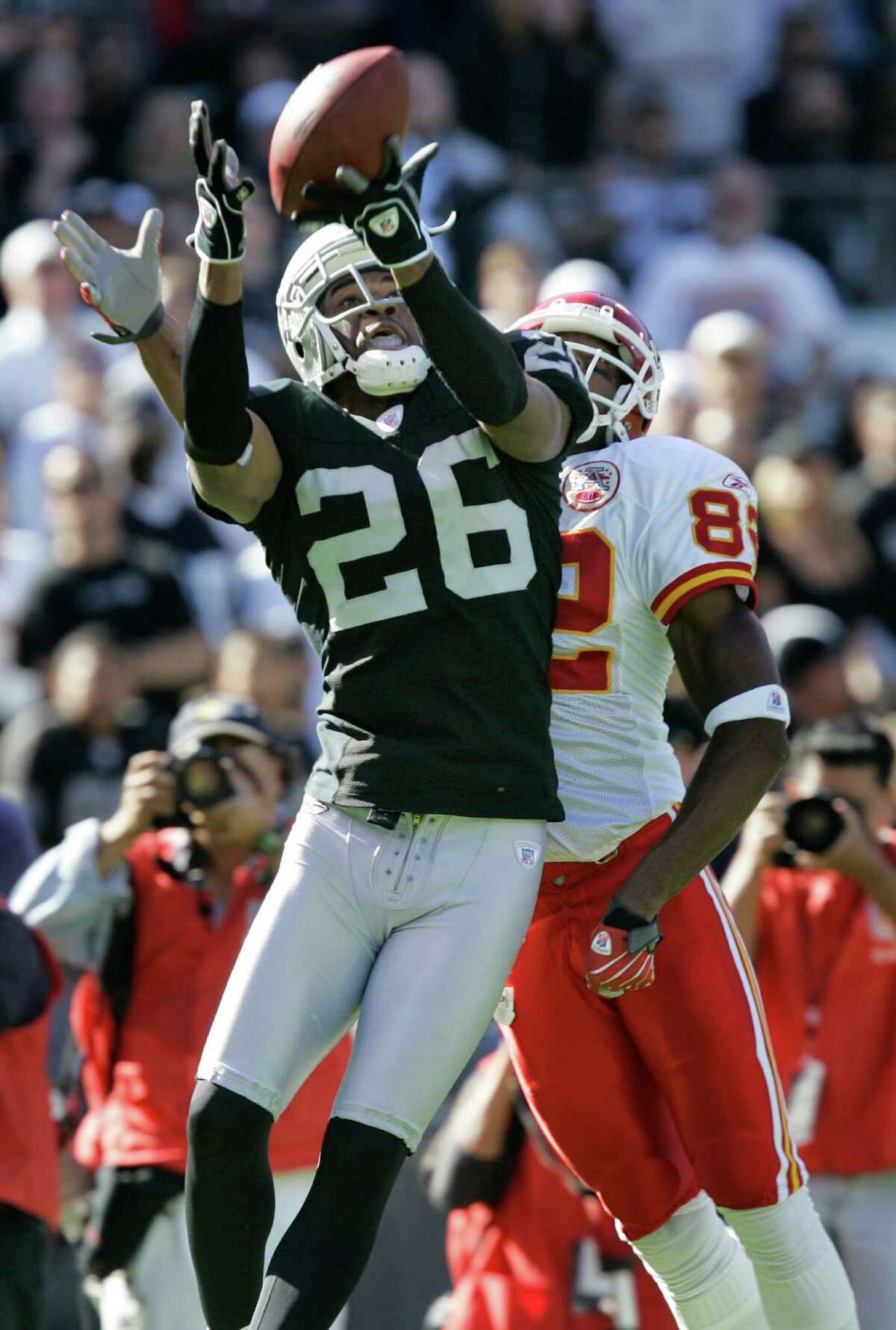 Oakland Raiders cornerback Stanford Routt (26) intercepts a pass intended for Kansas City Chiefs wide receiver Dwayne Bowe during the third quarter of an NFL football game in Oakland, Calif., Sunday, Oct. 21, 2007. Kansas City won, 12-10.