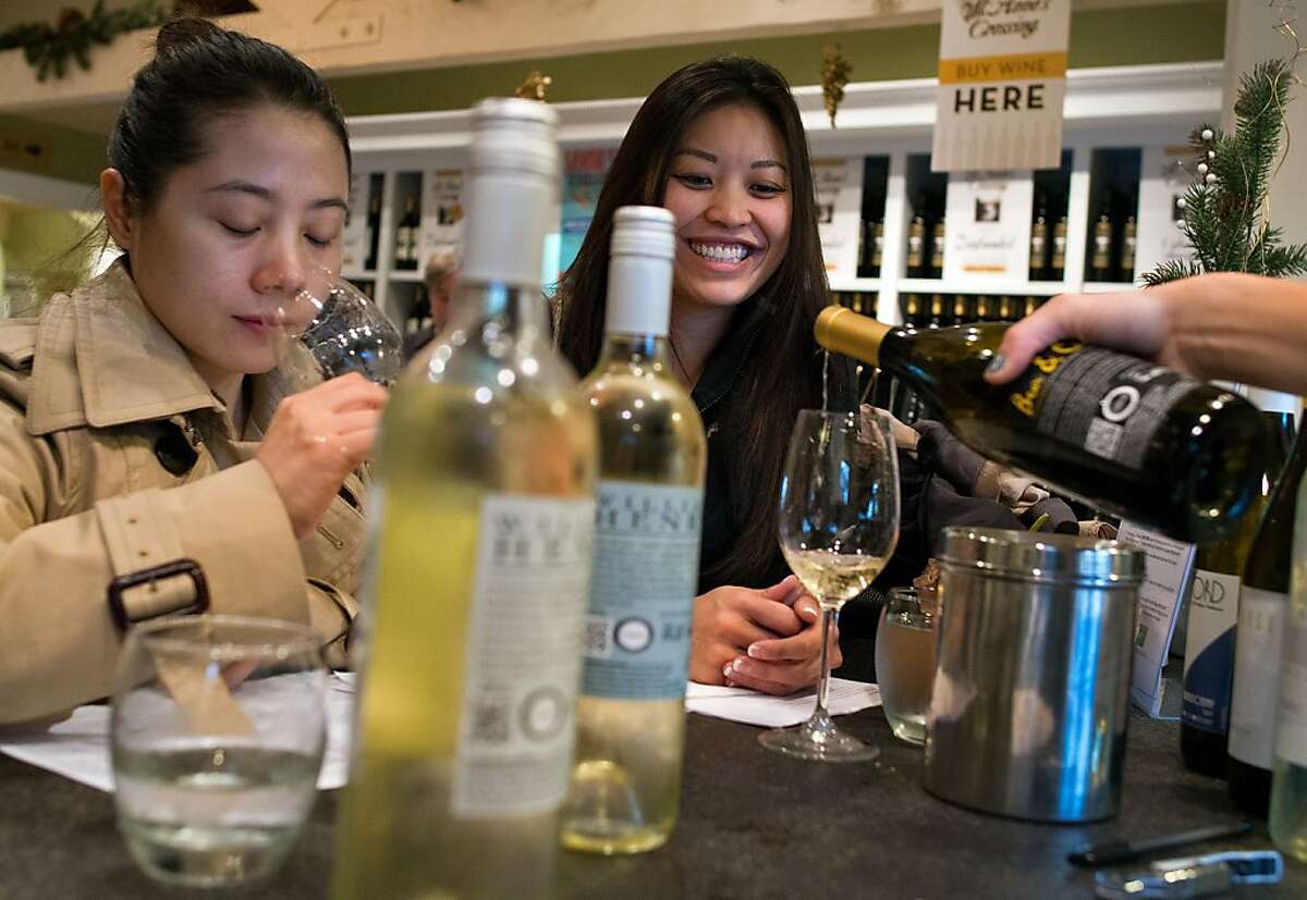 Lijun Mo, left, general manager of Ningbo Free Trade Zone Prince Mazingan Wine Co., Ltd., and translator Lily Wang taste a variety of white wines they intend to purchase for distribution in China at the Nakedwines.com wine studio and tasting room in Kenwood, Calif. on November 30, 2012.