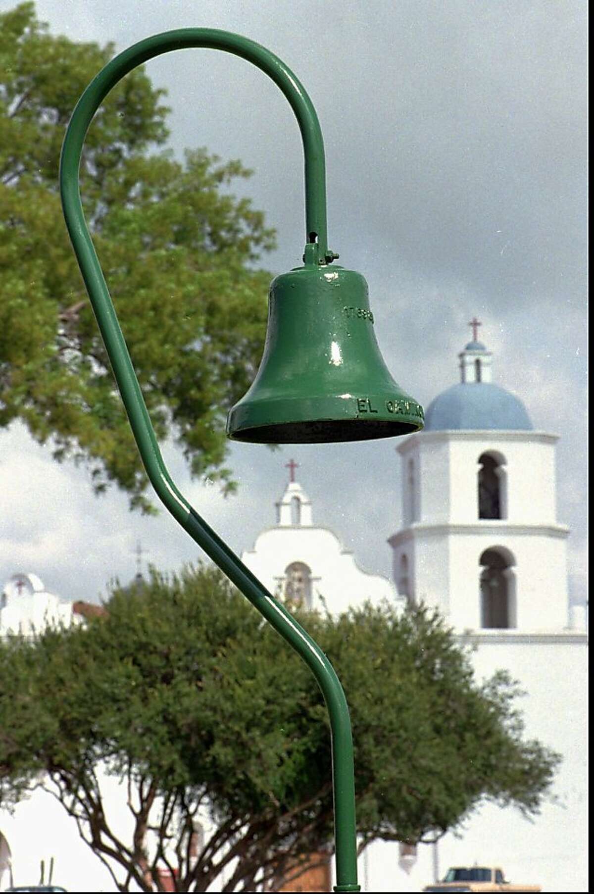 A mission bell leads the way to the Mission San Luis Rey in Oceanside, Calif. Wednesday, March 4, 1998. A campaign has started to reinstall the bells along the historic El Camino Real, the route connecting California's chain of missions. At one time 450 metal bells, weighing 92 pounds and set in the curve of an 11-foot pole shaped like a shepards crook, lined the El Camino route. (AP Photo/Union Tribune, Howard Lipin) ALSO RAN: 3/25/98.