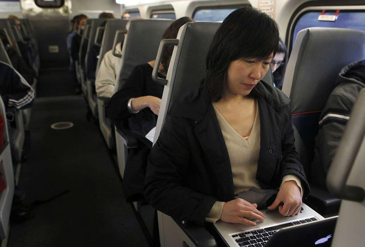 Zhian Zweiger works on her laptop using a wireless data card during her commute on Caltrain in San Bruno, Calif. on Tuesday, Dec. 4, 2012. Caltrain still doesn't offer wifi access on board despite repeated requests from regular passengers.