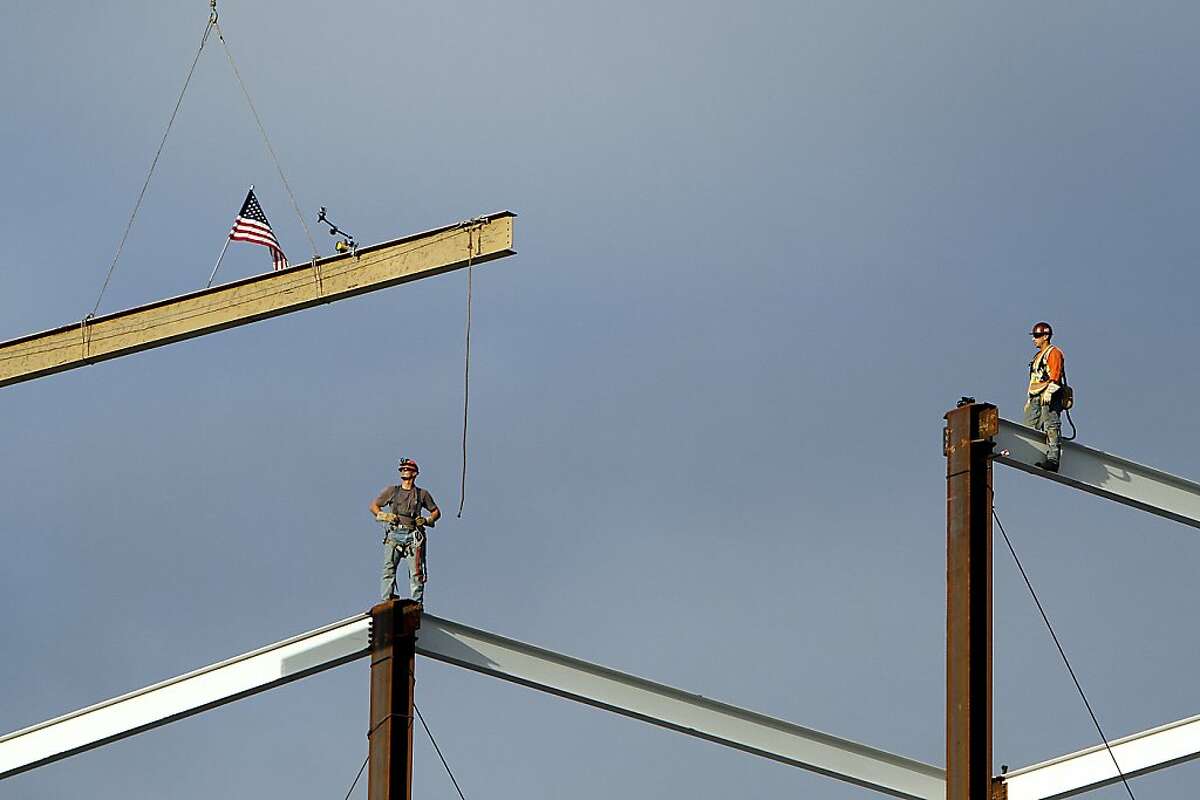 Steel workers wait as a signed I-beam is lifted into place at the highest point of the new 49ers stadium during the traditional Topping Off ceremony in Santa Clara, Calif., Thursday, December 6, 2012.