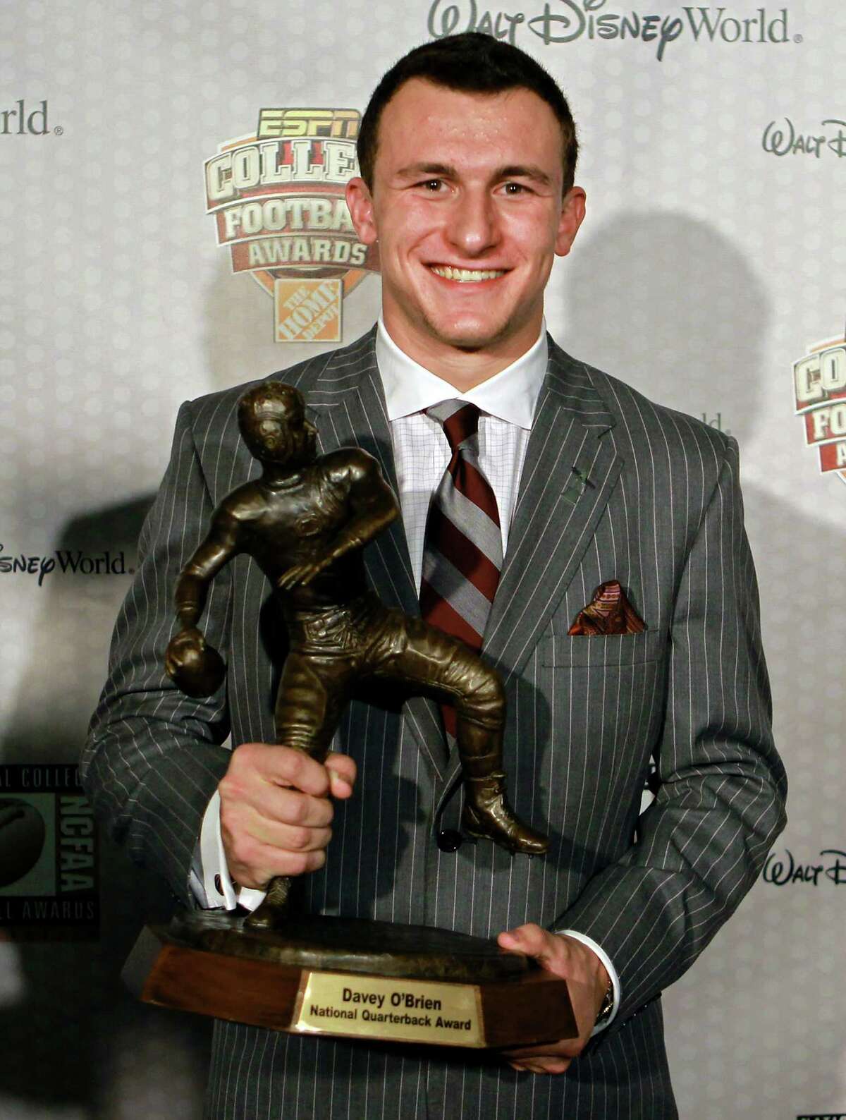 Texas A&M quarterback Johnny Manziel displays his trophy for the Davey O'Brien Award after being named the nation's best quarterback at the Home Depot College Football Awards in Lake Buena Vista, Fla., Thursday, Dec. 6, 2012. (AP Photo/John Raoux)
