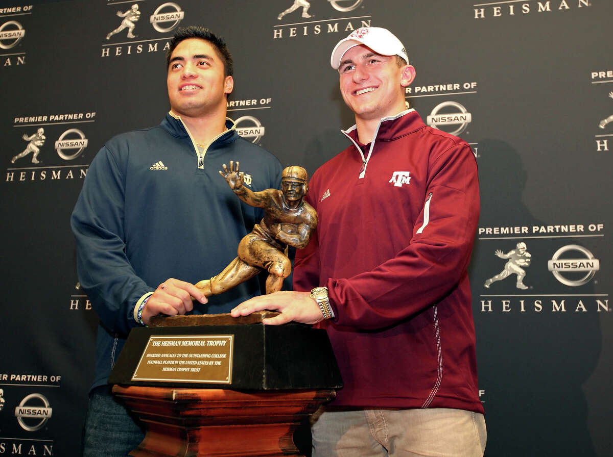 Heisman finalists Notre Dame's linebacker Manti Te'o and Texas A&M's quarterback Johnny Manziel pose with the Heisman Trophy during a press conference Friday Dec. 7, 2012 at the New York Marriott Marquis hotel in New York, New York. Not pictured is Heisman finalist Kansas State's quarterback Collin Klein.