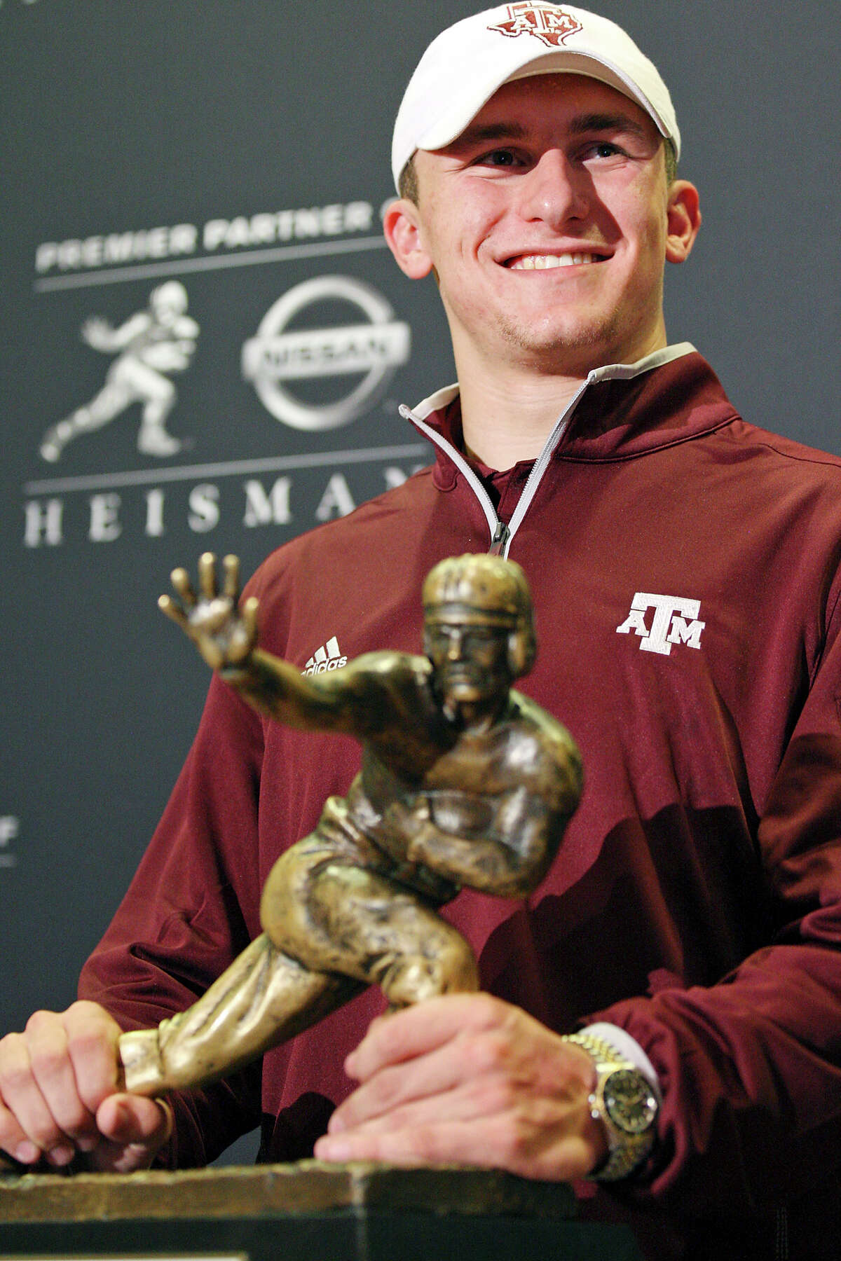 Heisman finalist Texas A&M's quarterback Johnny Manziel pose with the Heisman Trophy during a press conference Friday Dec. 7, 2012 at the New York Marriott Marquis hotel in New York, New York.